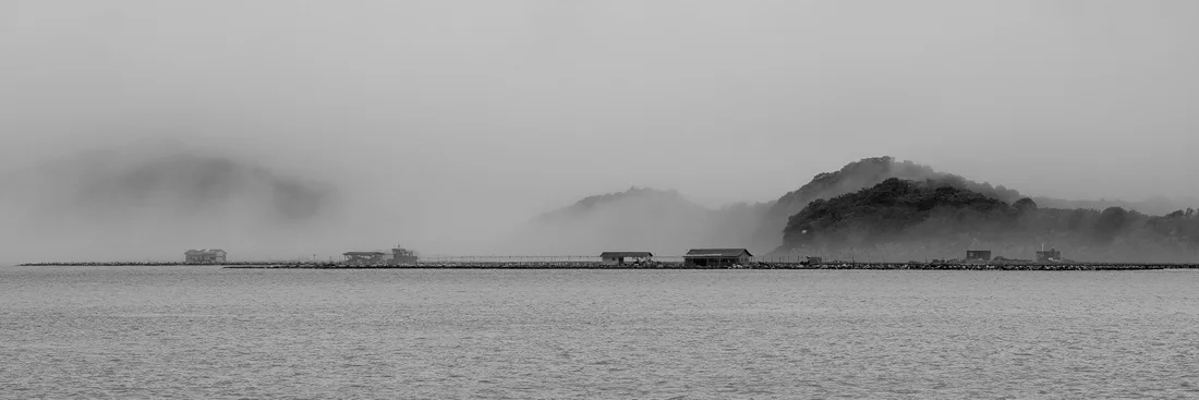 黑白全景中的雾山、水面和岸边屋舍